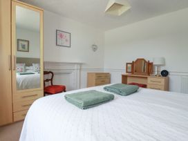 A bedroom with a bed and dresser at Penrose Farm Cottage St Keverne