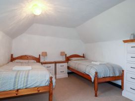 A bedroom with two beds and bedside tables at Penrose Farm Cottage St Keverne