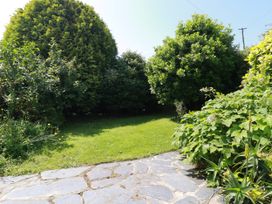 A garden with a stone path and shrubs at Penrose Farm Cottage St Keverne