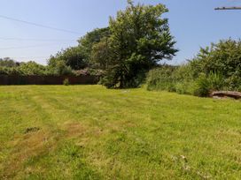 A garden with grass and trees at Penrose Farm Cottage St Keverne