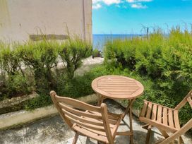A garden with a table and chairs looking towards the sea at Pegs in Porthleven