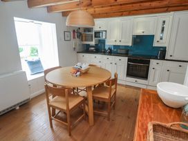 A kitchen with a round table and chairs at Pegs in Porthleven