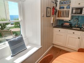 A kitchen with a table and window at Pegs in Porthleven