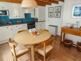 A kitchen with a round table and chairs at Pegs in Porthleven