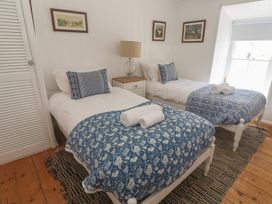A bedroom with two beds and a nightstand at Pegs in Porthleven