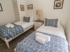 A bedroom with twin beds and a bedside table at Pegs in Porthleven
