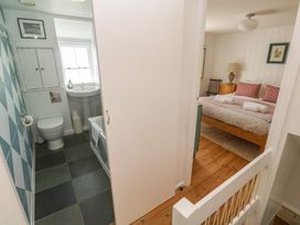 A bathroom with toilet and sink viewed from a hallway at Pegs in Porthleven