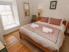 A bedroom with a bed and nightstand at Pegs in Porthleven