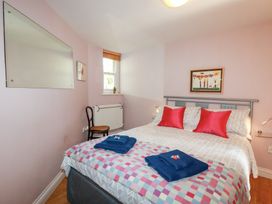 A bedroom with a bed and chair at Mithian Cottage in St Agnes