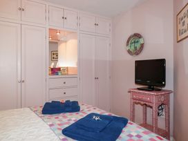 A bedroom with a wardrobe and television at Mithian Cottage, St Agnes