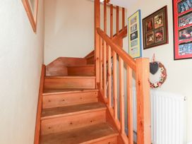 A staircase with pictures on the wall at Mithian Cottage, St Agnes