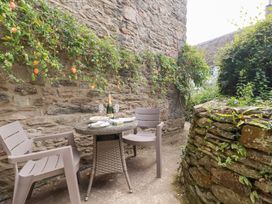 An outdoor seating area with a table and chairs at Mithian Cottage in St Agnes