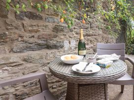 An outdoor dining area with a table set for snacks and drinks at Mithian Cottage St Agnes
