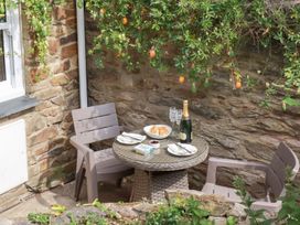 A table with chairs and champagne at Mithian Cottage St Agnes