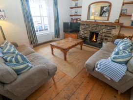 A living room with a coffee table, two sofas, and a fireplace at 1 Dormer Villas in Portscatho