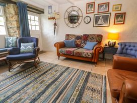A living room with a sofa and armchair at May Cottage in Pentewan
