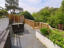 A garden with outdoor seating and a wooden fence at May Cottage in Pentewan