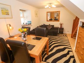 A living room with a dining area and a sofa at Godrevy Cottage in Hayle