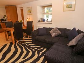 A living room with a sofa and dining area at Godrevy Cottage in Hayle