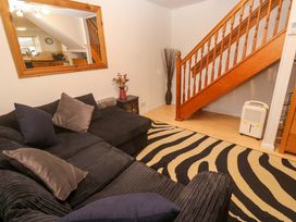 A living room with a sofa and stairs at Godrevy Cottage in Hayle