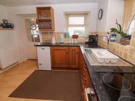 A kitchen with cabinets and appliances at Godrevy Cottage Hayle