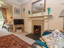 A living room with a television and fireplace at Banneth in Helford
