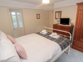 A bedroom with a bed and television at Banneth in Helford