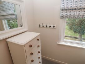 A bedroom with a chest of drawers and coat hooks at Banneth in Helford