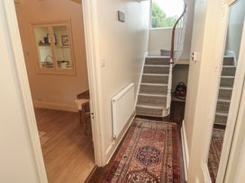 A hallway with staircase and chair at Banneth in Helford