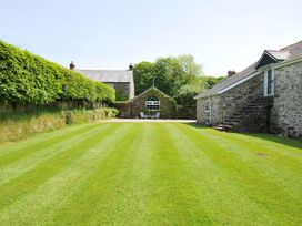 A garden with grass and buildings at Trevenning Chapel Near Port Isaac