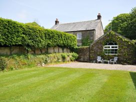 A garden with a house and seating area at Trevenning Chapel Near Port Isaac