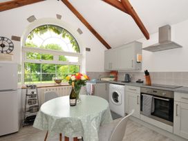 A kitchen with a table and chairs beside a window at Trevenning Chapel near Port Isaac