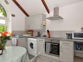 A kitchen with appliances and a dining table at Trevenning Chapel Near Port Isaac