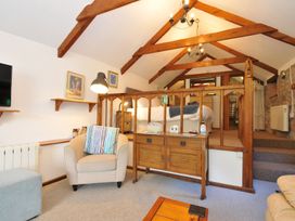 A living room with furniture and a bed area at Trevenning Chapel near Port Isaac