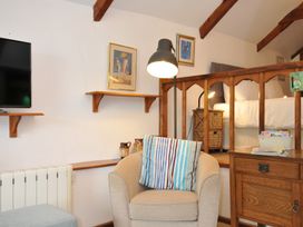 A snug with a television and an armchair at Trevenning Chapel near Port Isaac