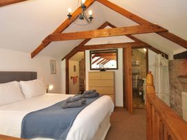 A bedroom with a bed and wooden furniture at Trevenning Chapel Near Port Isaac