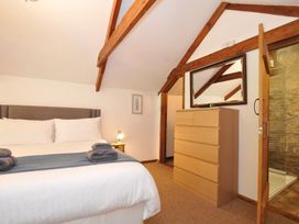 A bedroom with a bed and dresser at Trevenning Chapel Near Port Isaac