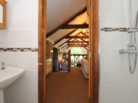 A bathroom with a wash basin and shower leading to a living room at Trevenning Chapel Near Port Isaac