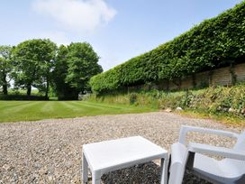 A garden with a gravel area and trees at Trevenning Chapel near Port Isaac