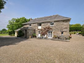 A stone house with outdoor furniture at Trevenning Barn Near Port Isaac