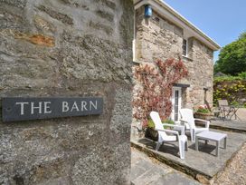 An outdoor seating area with chairs and a table at Trevenning Barn near Port Isaac