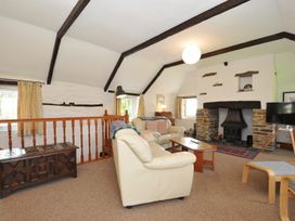 A living room with a fireplace and sofa at Trevenning Barn near Port Isaac