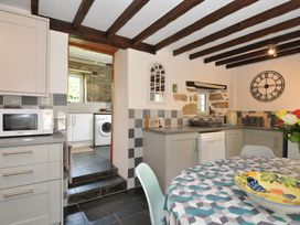 A kitchen with appliances and a table at Trevenning Barn Near Port Isaac