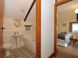 A bathroom with a sink and toilet leading to a bedroom at Trevenning Barn near Port Isaac