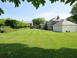 A garden with grass and trees at Trevenning Barn near Port Isaac