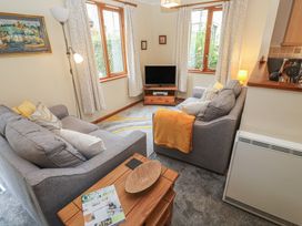 A living room with a sofa and a TV at Two Hoots in Falmouth