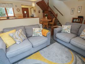 A living room with sofas and a dining area at Two Hoots in Falmouth