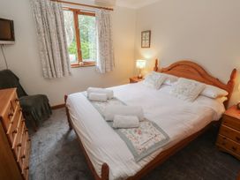 A bedroom with a double bed and dresser at Two Hoots in Falmouth