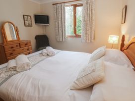 A bedroom with a bed and dresser at Two Hoots in Falmouth