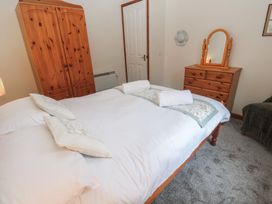 A bedroom with a bed and wardrobe at Two Hoots in Falmouth